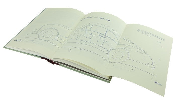 Open blueprint-style book pages with line drawings of a car