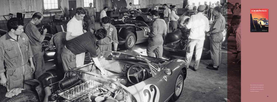 Classic race car with open engine bay, mechanics gathered in a workshop area
