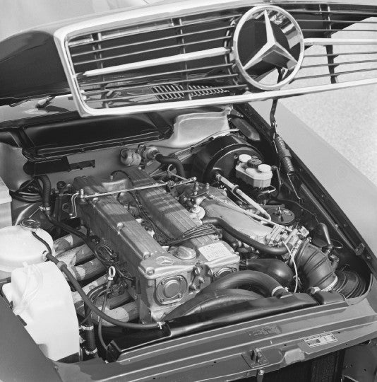 Automotive catalogue raisonné book spread with photo of engine bay and grille