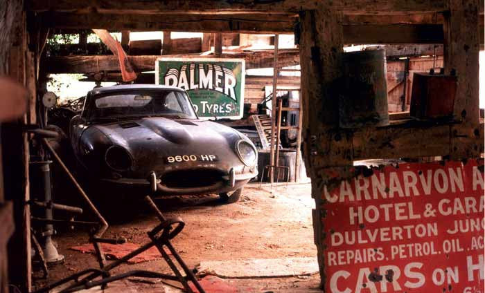 Book page with a dark vintage car in a rusty workshop with tire sign