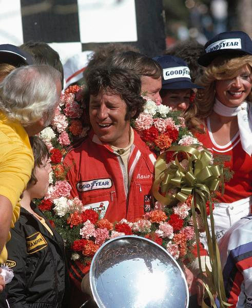 Formula 1 1970s book page with driver holding flowers during an award celebration