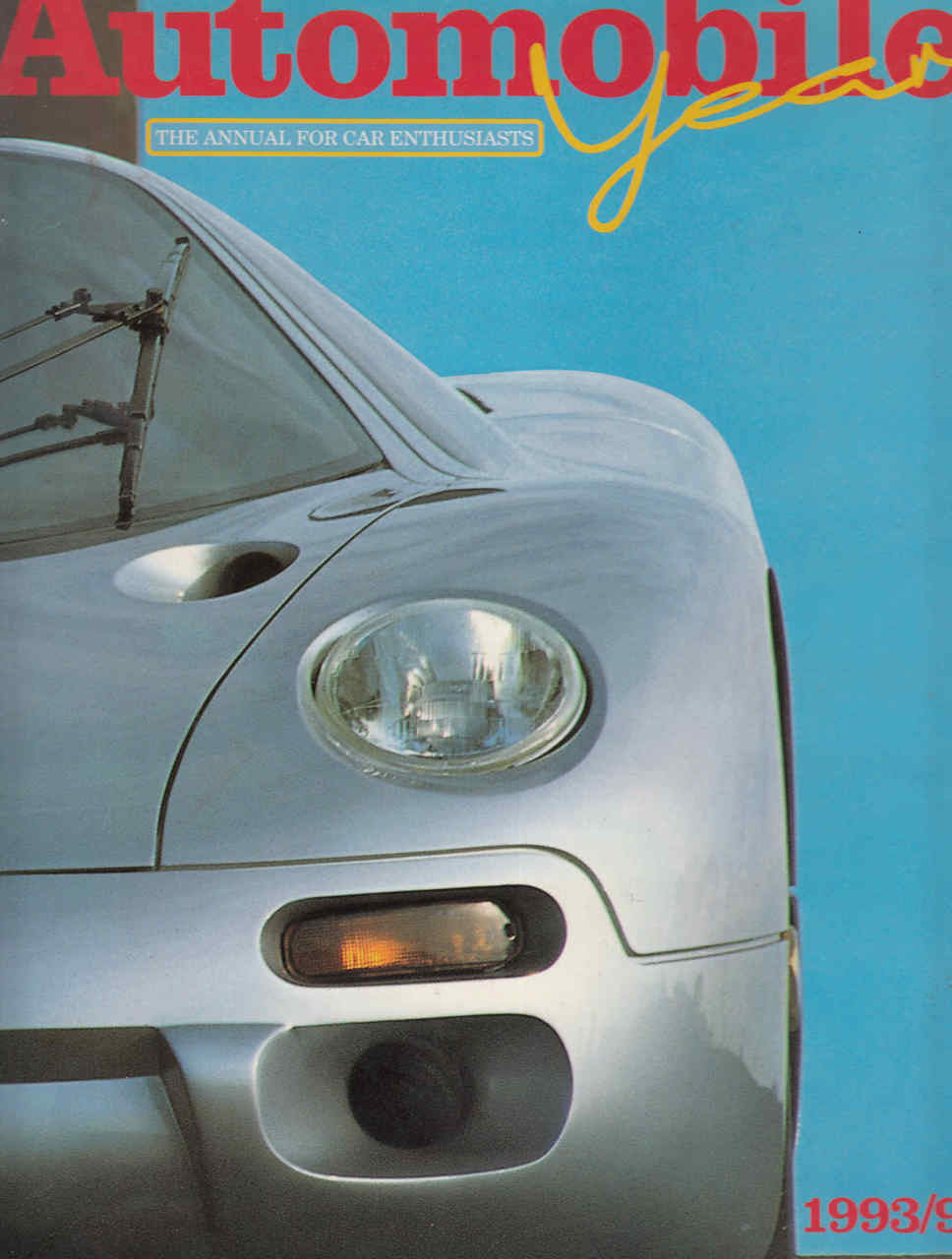 Front view of a light silver sports car with round headlights and lower grille