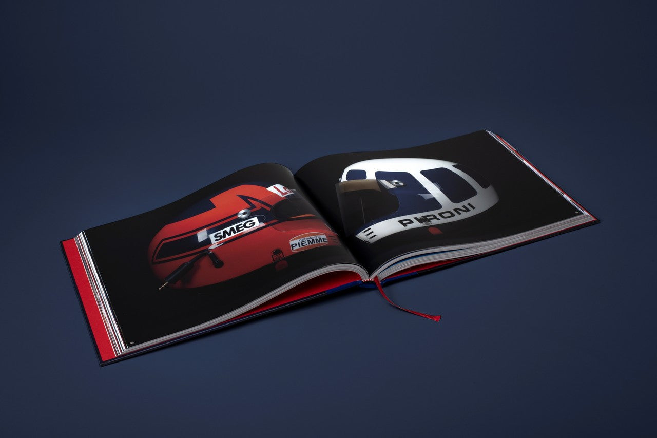 Opened helmet-themed book spread showing two large team helmet images on opposite pages.
