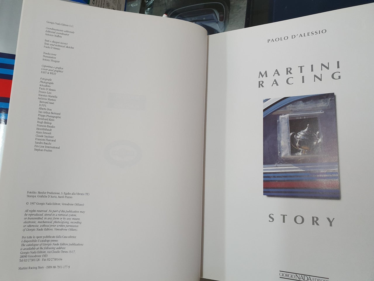 Hardcover racing story book open, text left and Martini photo right