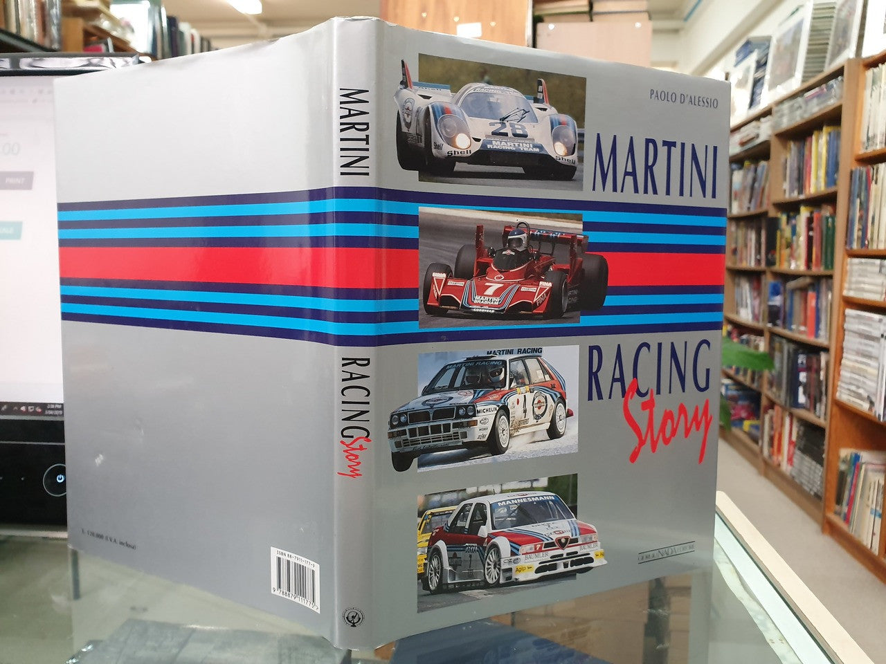 Hardcover racing story book back cover with blue/red stripes and car photos