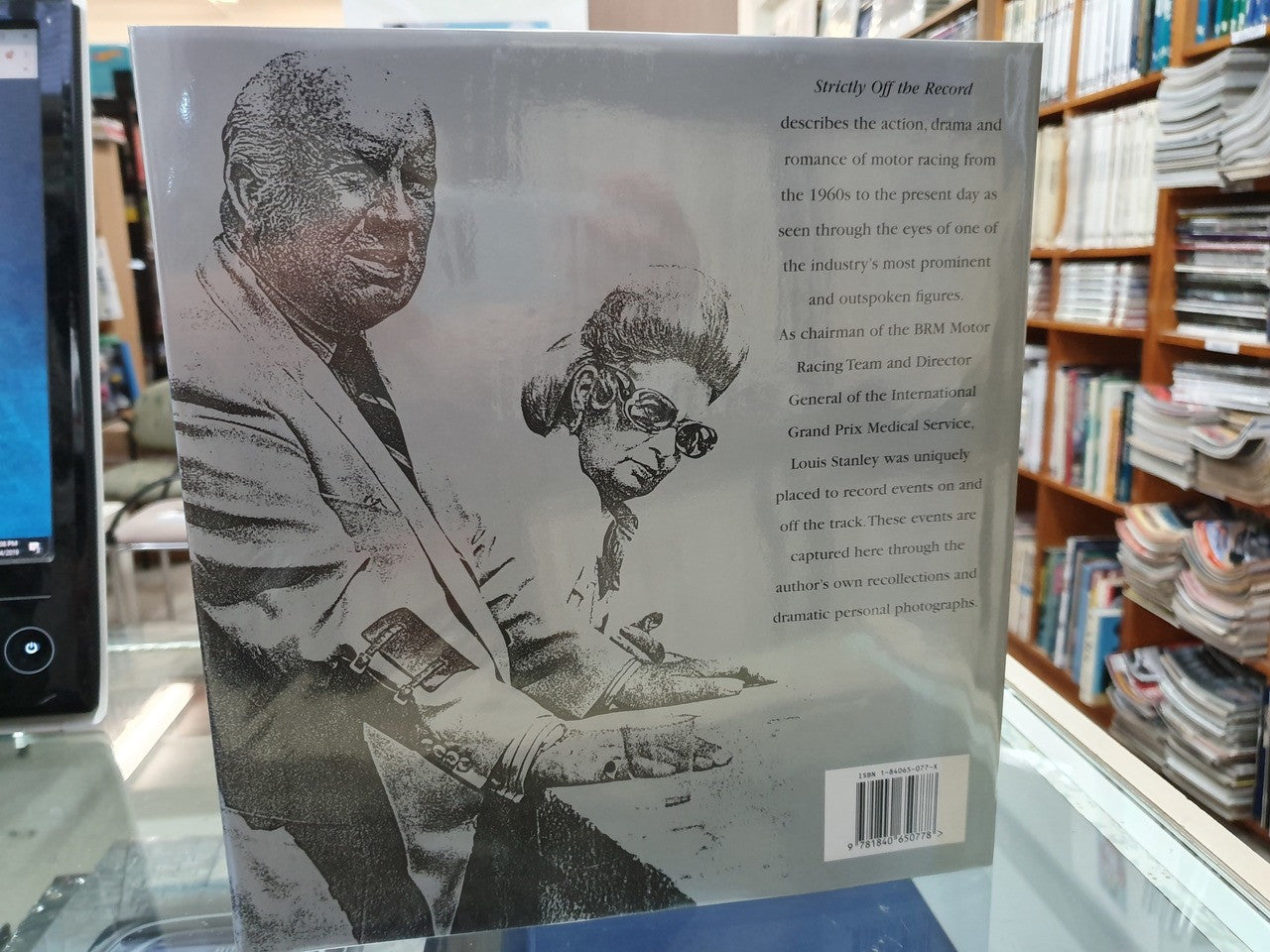 Hardcover book closed, showing back cover with head-and-shoulders illustration