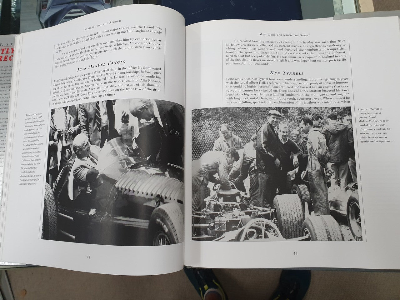 Hardcover book open to pages with black-and-white photos of people and cars