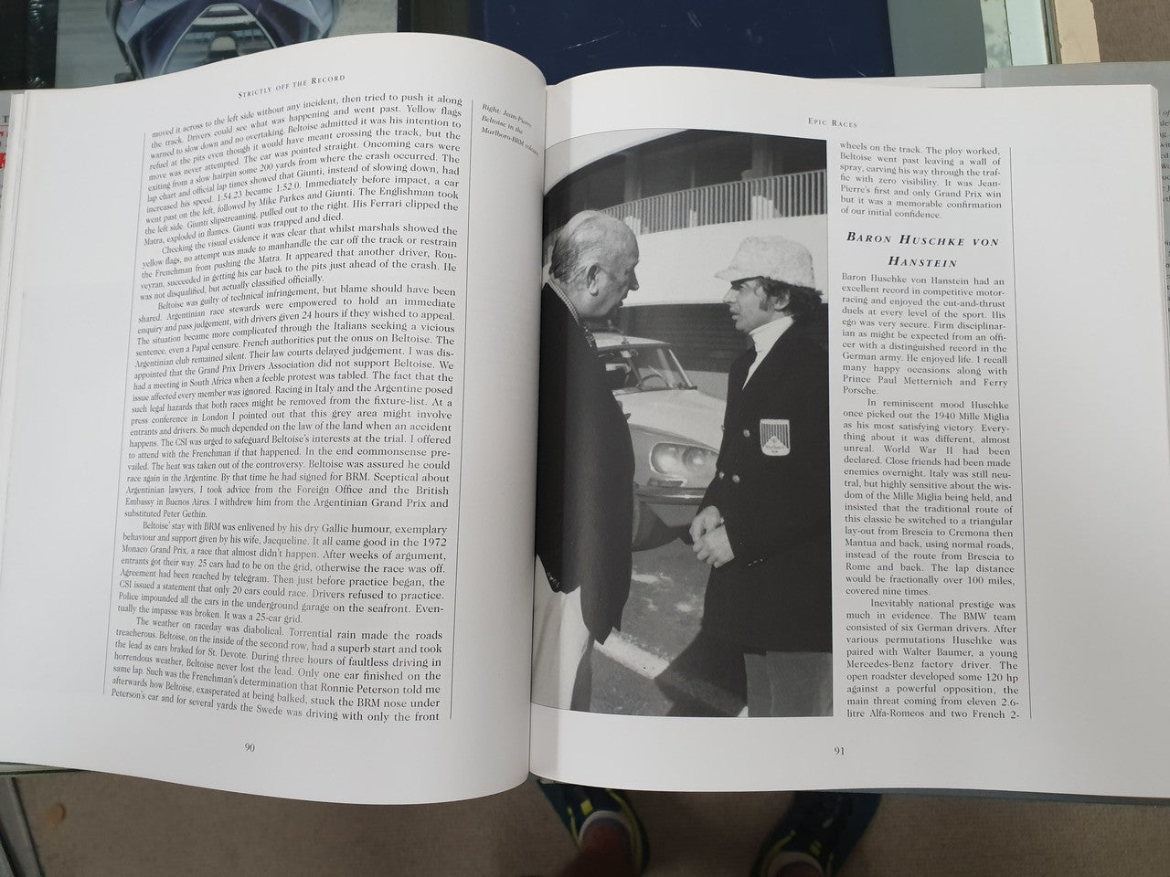 Hardcover book open to pages with dense text and black-and-white portrait photos