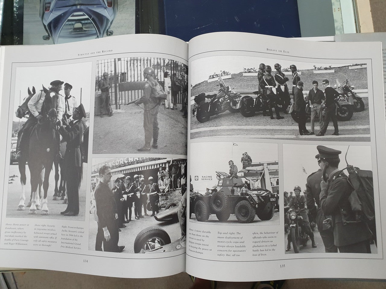 Hardcover book open to multiple black-and-white photos of vehicles and people
