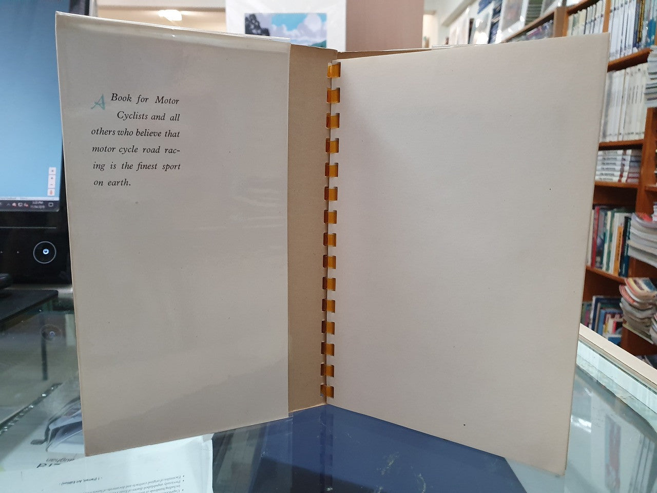 Open hardcover book with blank pages and a brown comb spine binding.
