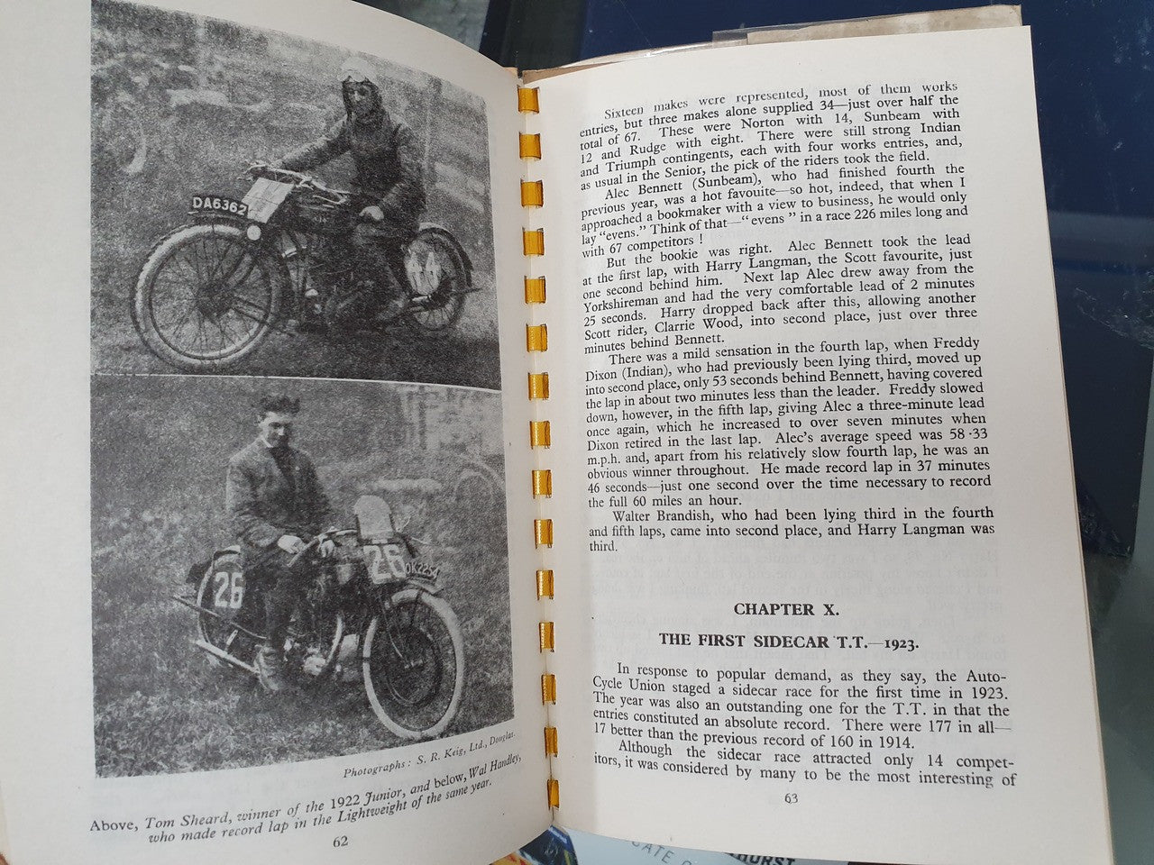 Open hardcover book page with motor racing photo spread and chapter text on right.