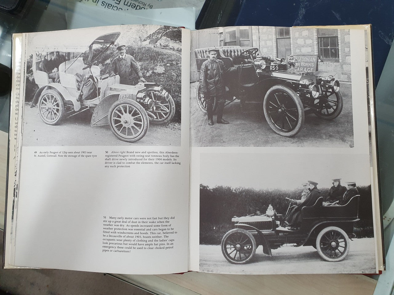 Open book spread with black-and-white vintage cars and bicycle photos