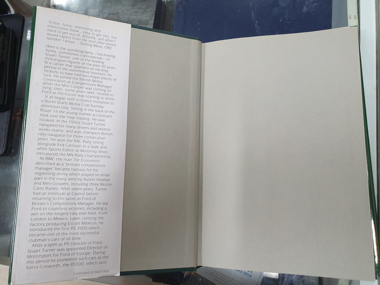 Open hardcover book with text column on left and blank page on right