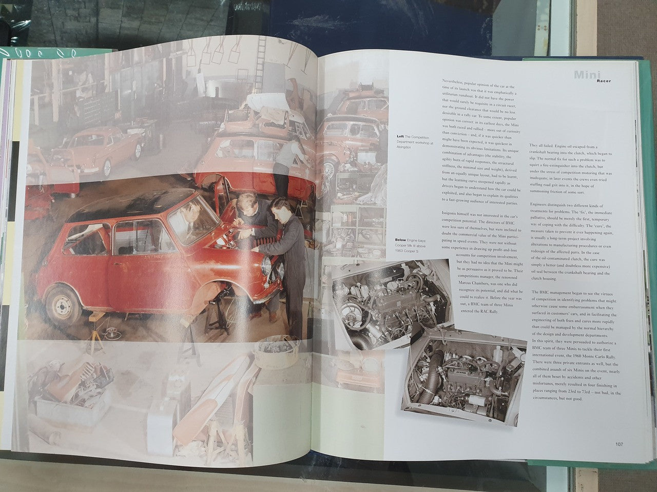 Open hardcover book spread with red Mini car photos and a person standing outside