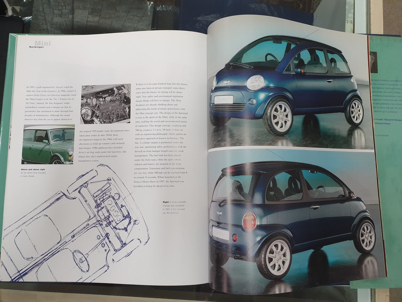 Open hardcover book spread with blue Mini car photos and technical line drawing