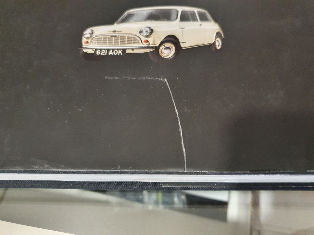 Classic car book cover, cream vintage Mini parked on dark background