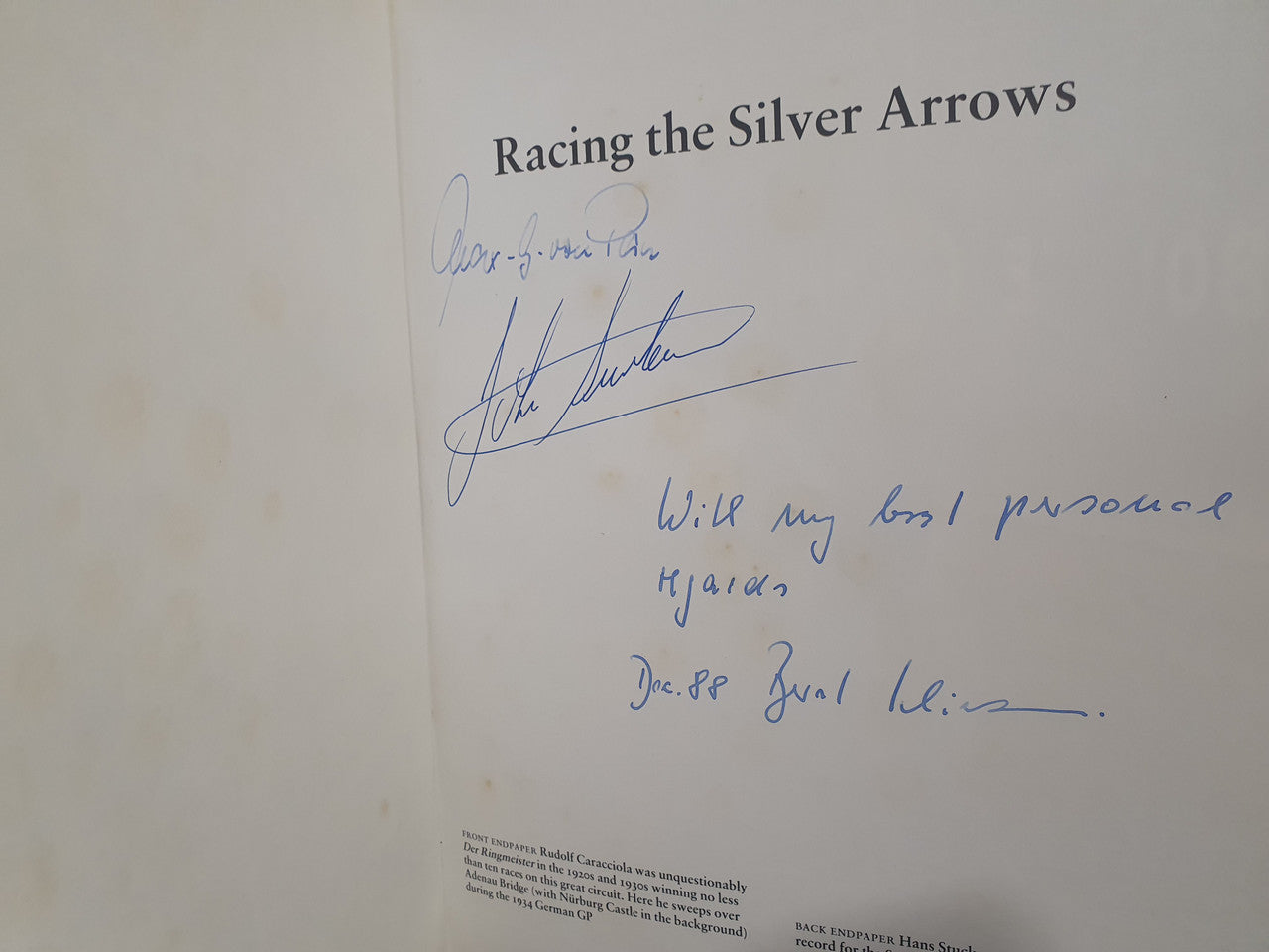 Autographed racing book page with handwritten signatures on white paper