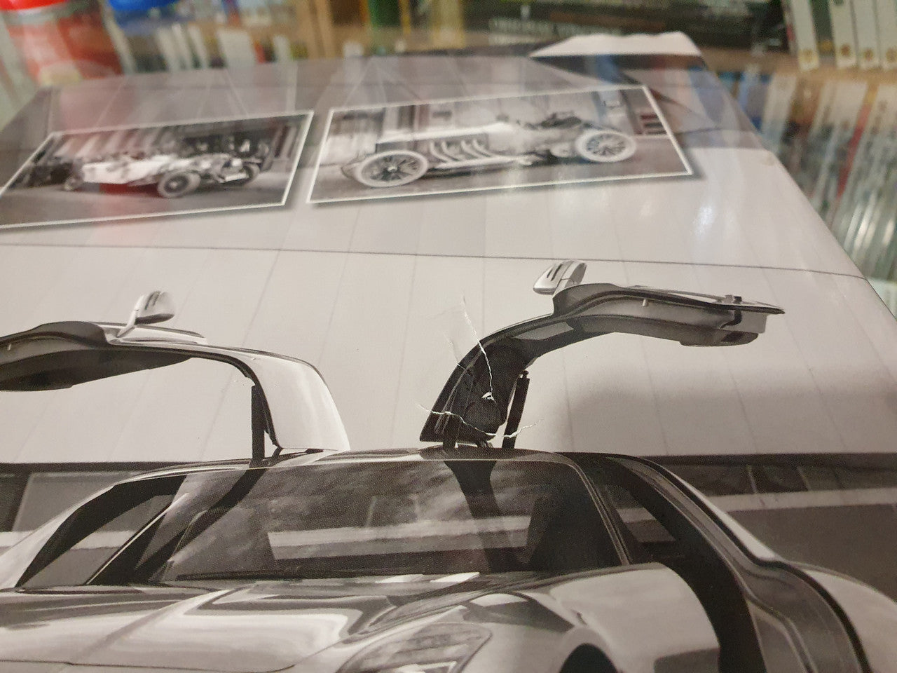 Open book spread featuring a white Mercedes-Benz supercar with raised hood