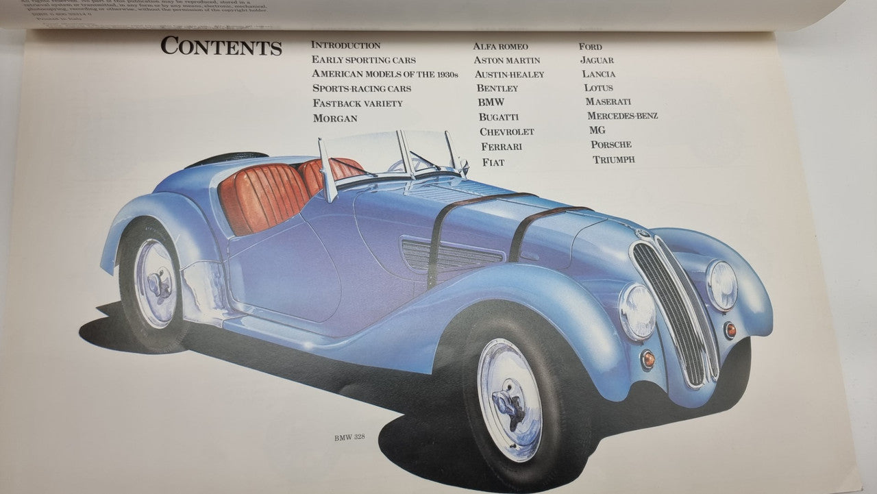 Light blue classic sports car illustration on open book page, front three-quarter view