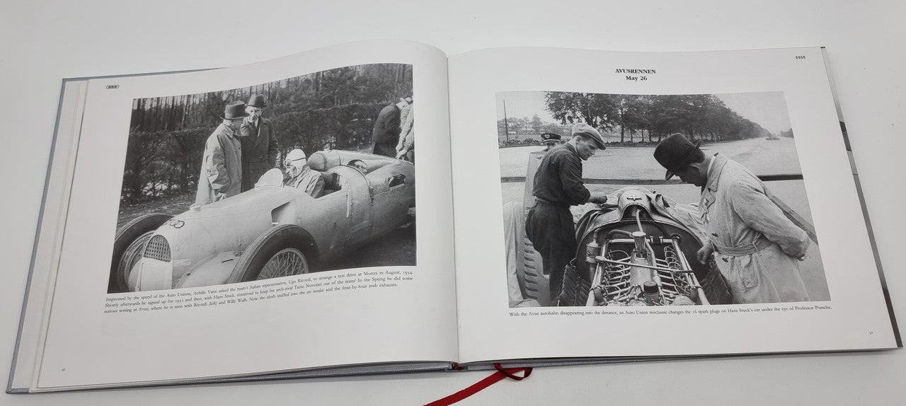 Open photo album spread with black-and-white images of cars and mechanics