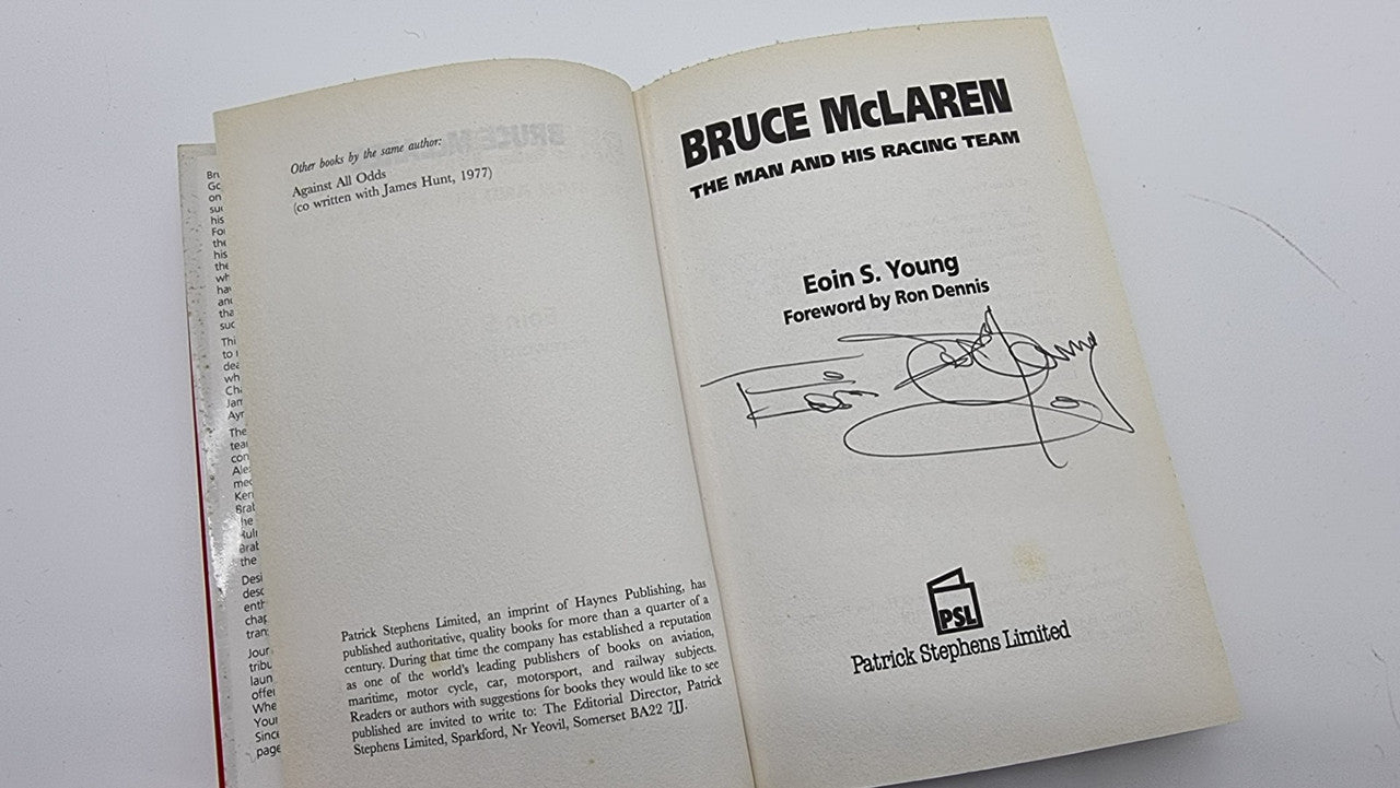 Open hardcover book showing title page and author dedication with signature