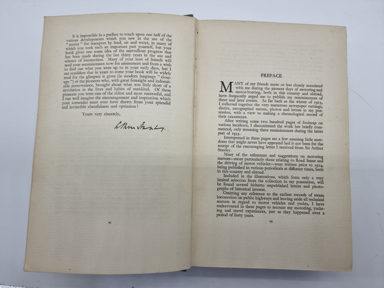 Open book with signature on left page and preface text on right page