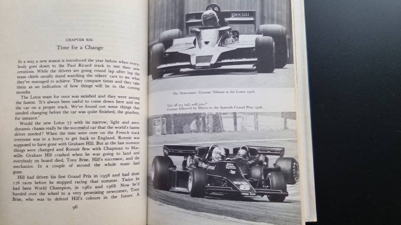 Book open to racing photo pages with caption lines and surrounding paragraphs of text