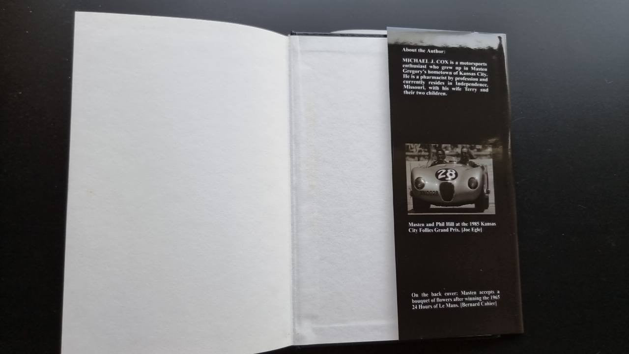 Motorsport photo history book, open pages with black info panel and small race car photo