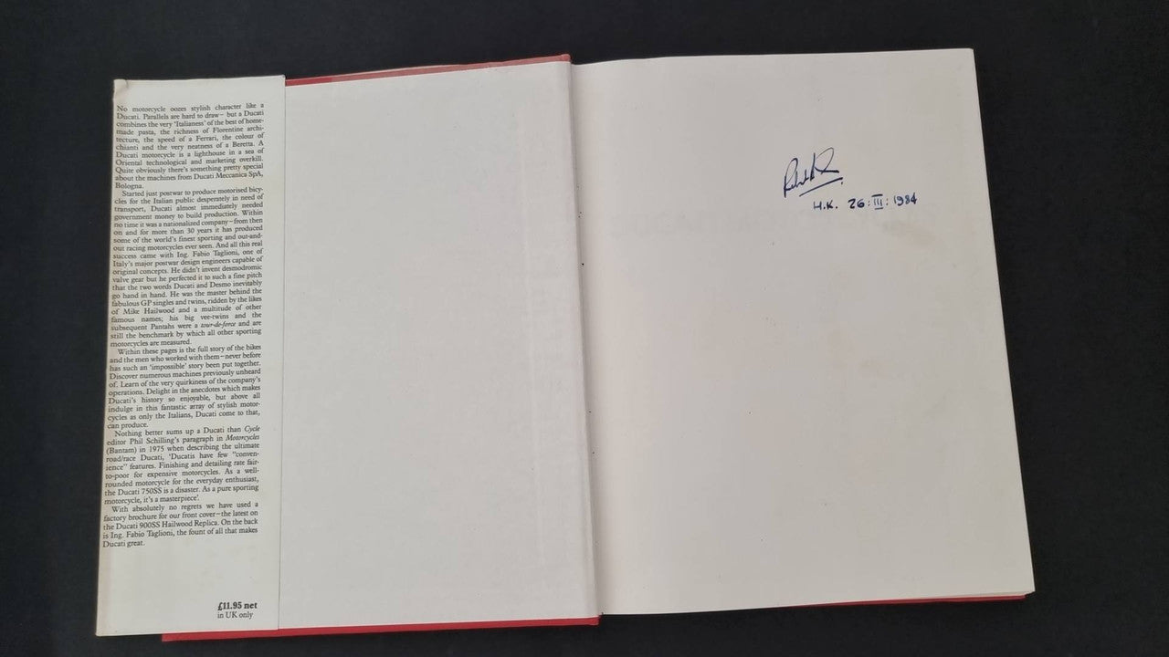 Open motorcycle book with text pages and handwritten signature on right page