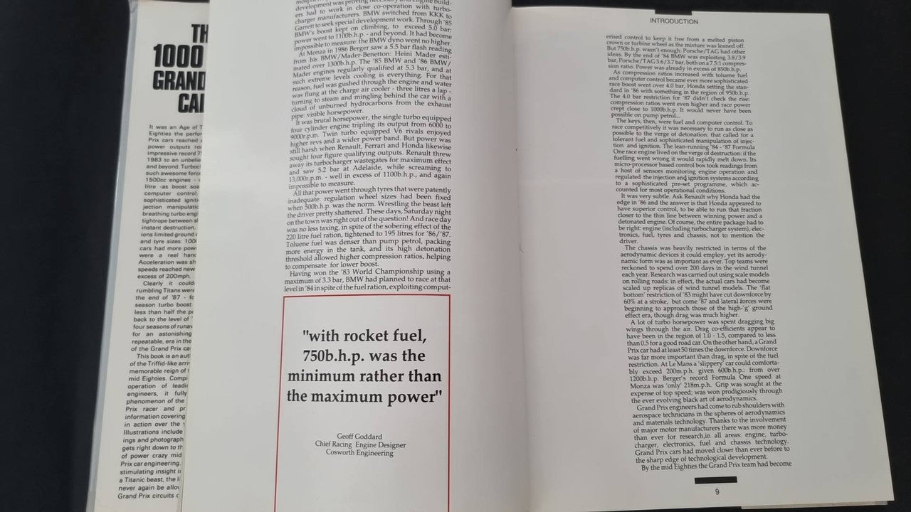 Opened motorsport book with two text-heavy pages and small car photo
