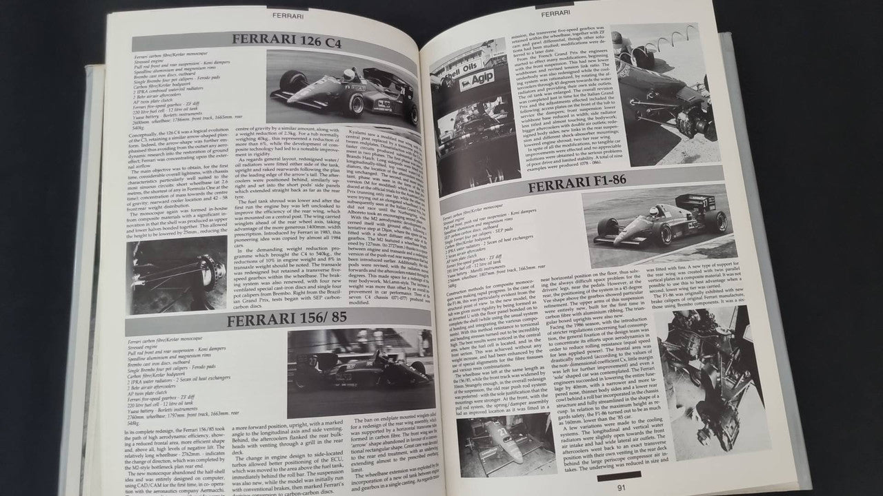 Opened motorsport book with multiple Ferrari car photos and dense articles
