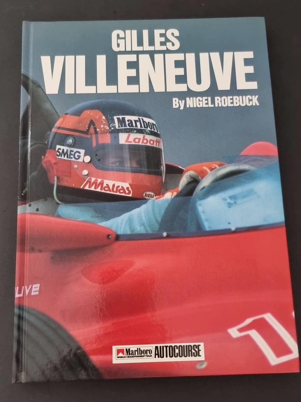Gilles Villeneuve racing book, front cover with red car nose and helmet