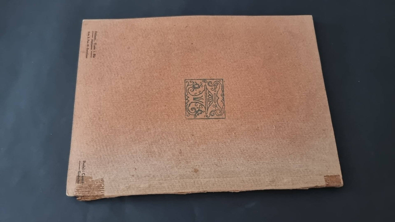 Vintage booklet back cover in textured beige with small decorative emblem