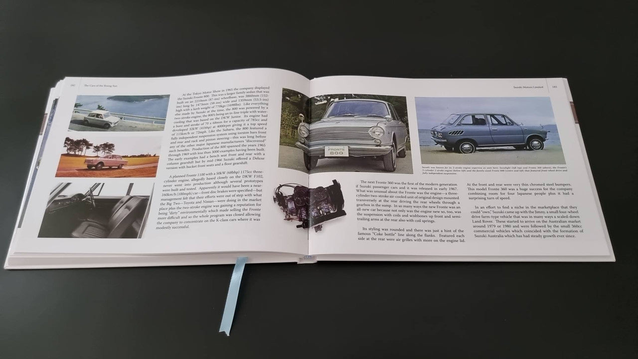 Book open with multiple classic car photos and dense text across pages