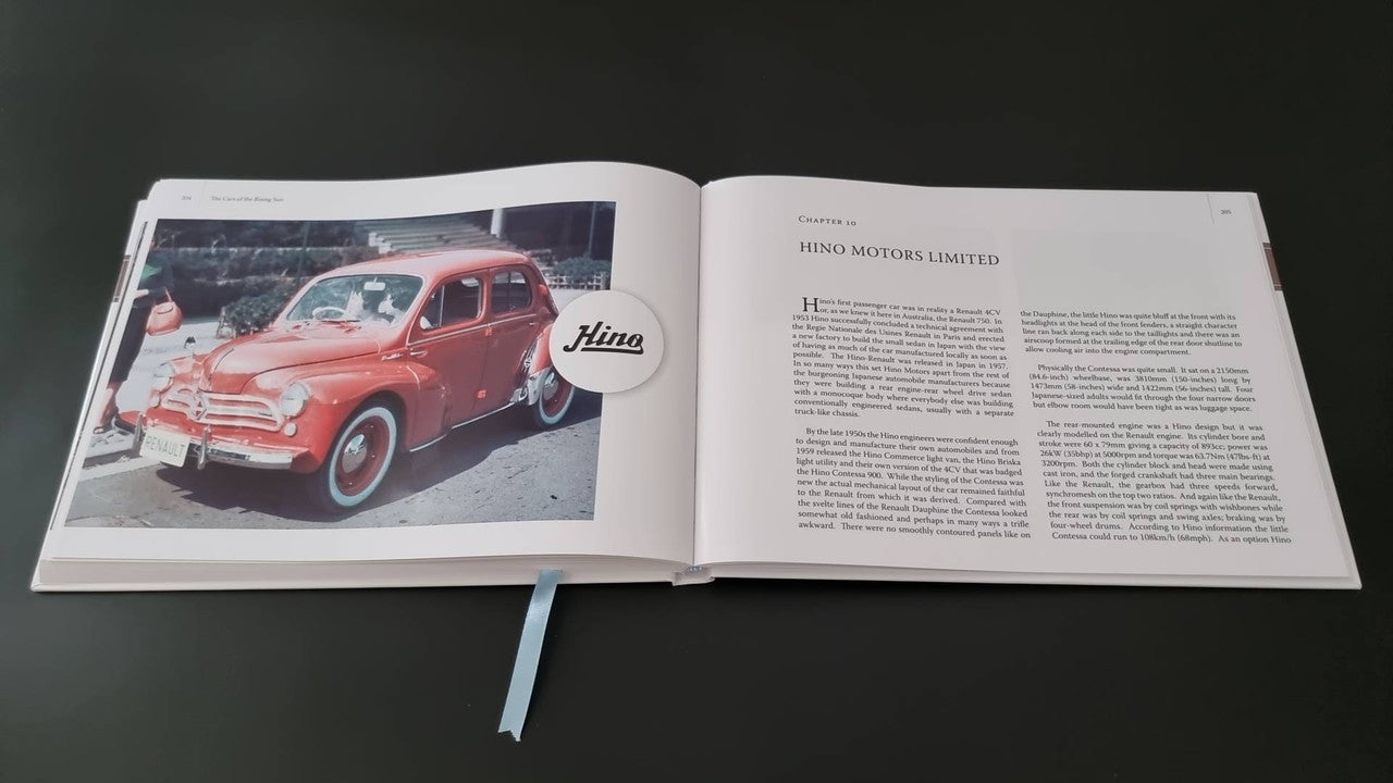 Book open showing a red classic car photo with circular inset and article text