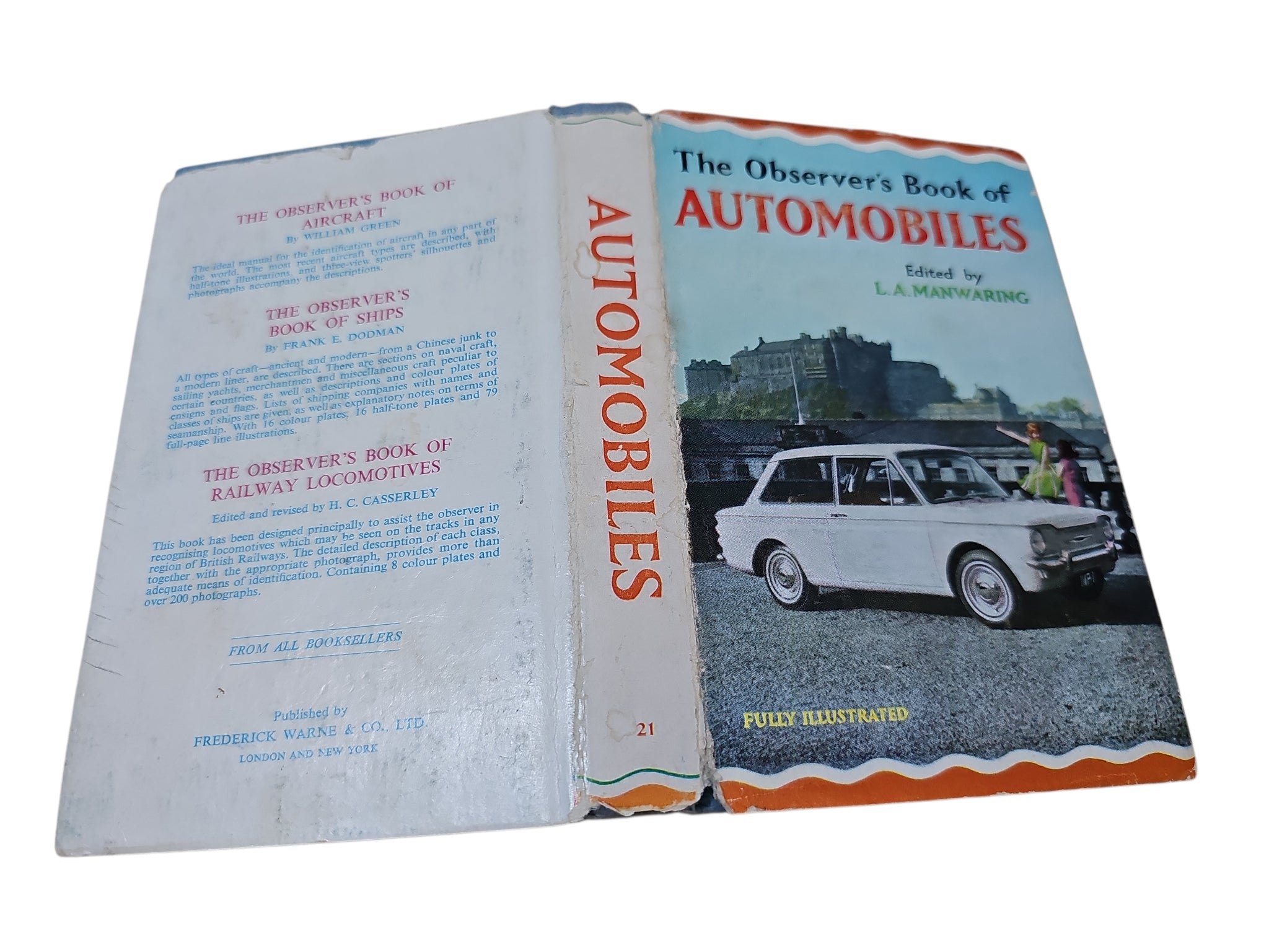 Opened Automobiles book with white pages and blue cover, showing title and car illustration