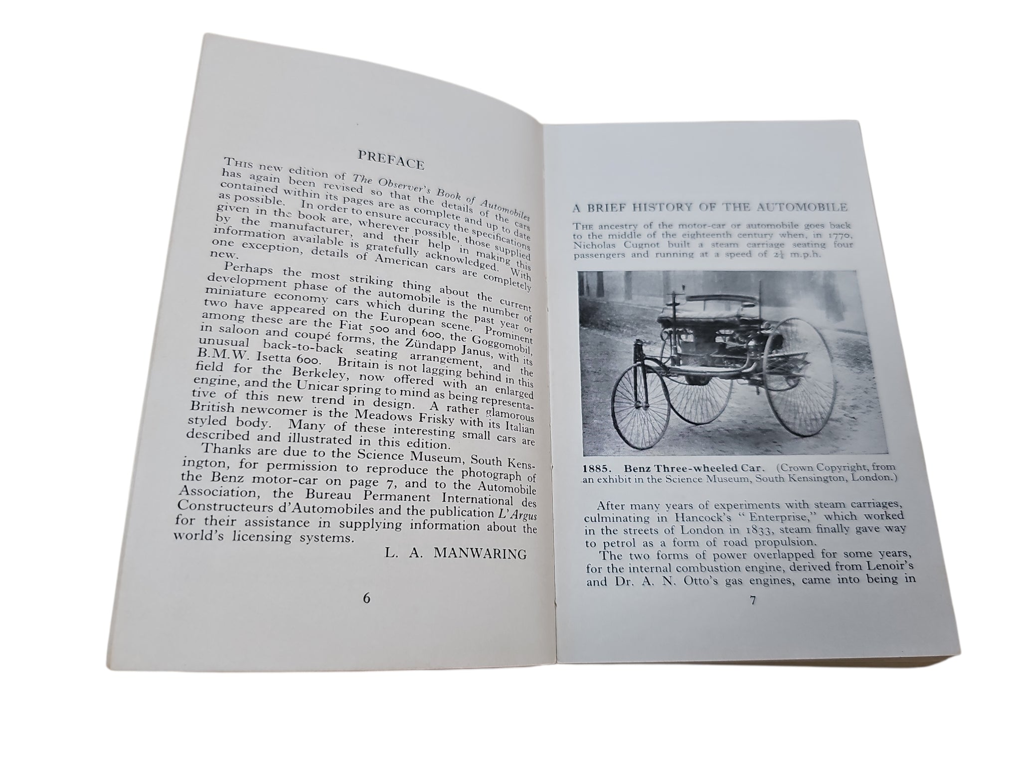 Open automobiles book with dense text and black-and-white car photos