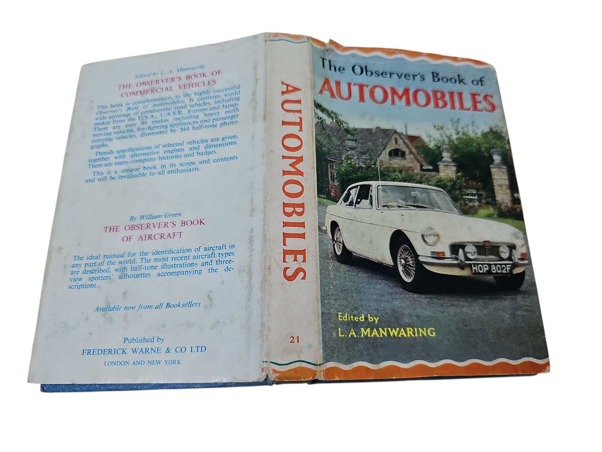 Open vintage automobile book showing cover art with a classic car and mirrored title page