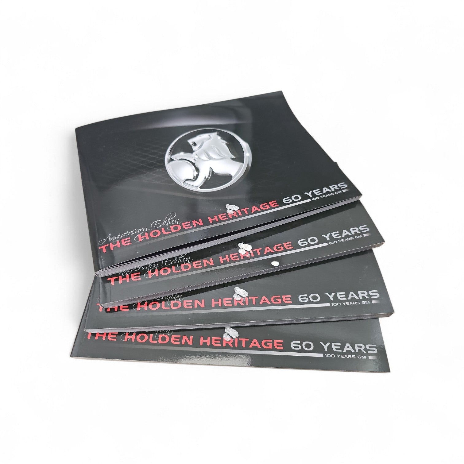 Stack of anniversary edition booklets with silver horse emblem and red 60 Years title