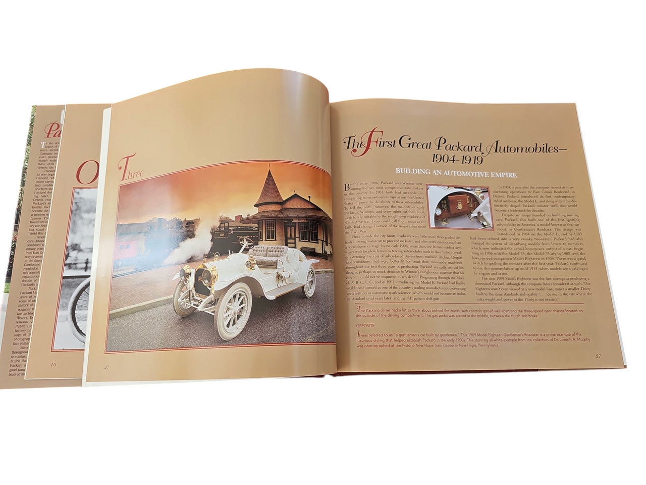 Packard hardcover book open pages with car photo and illustrated historic scene on the left