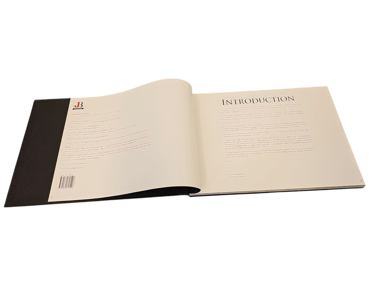 Commemorative race photo album open to Introduction pages, small print and barcode