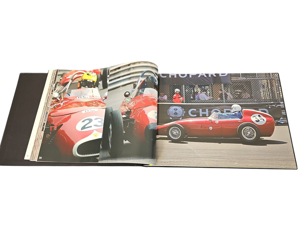 Commemorative race photo album spread with red race cars and track crews
