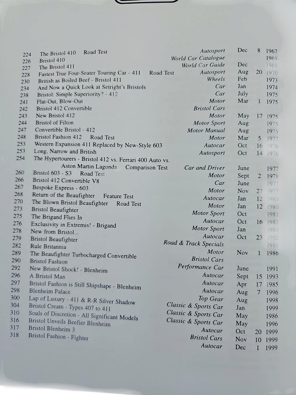 Hardcover book page close-up with lists of car models and dates