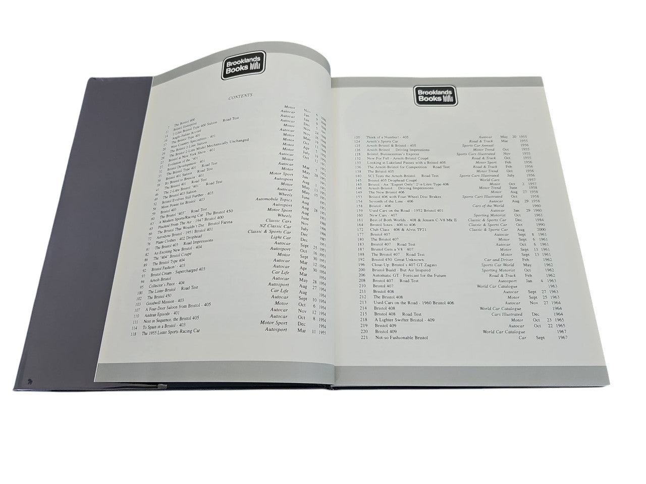 Open hardcover car book with two cream pages of dense text and dark covers
