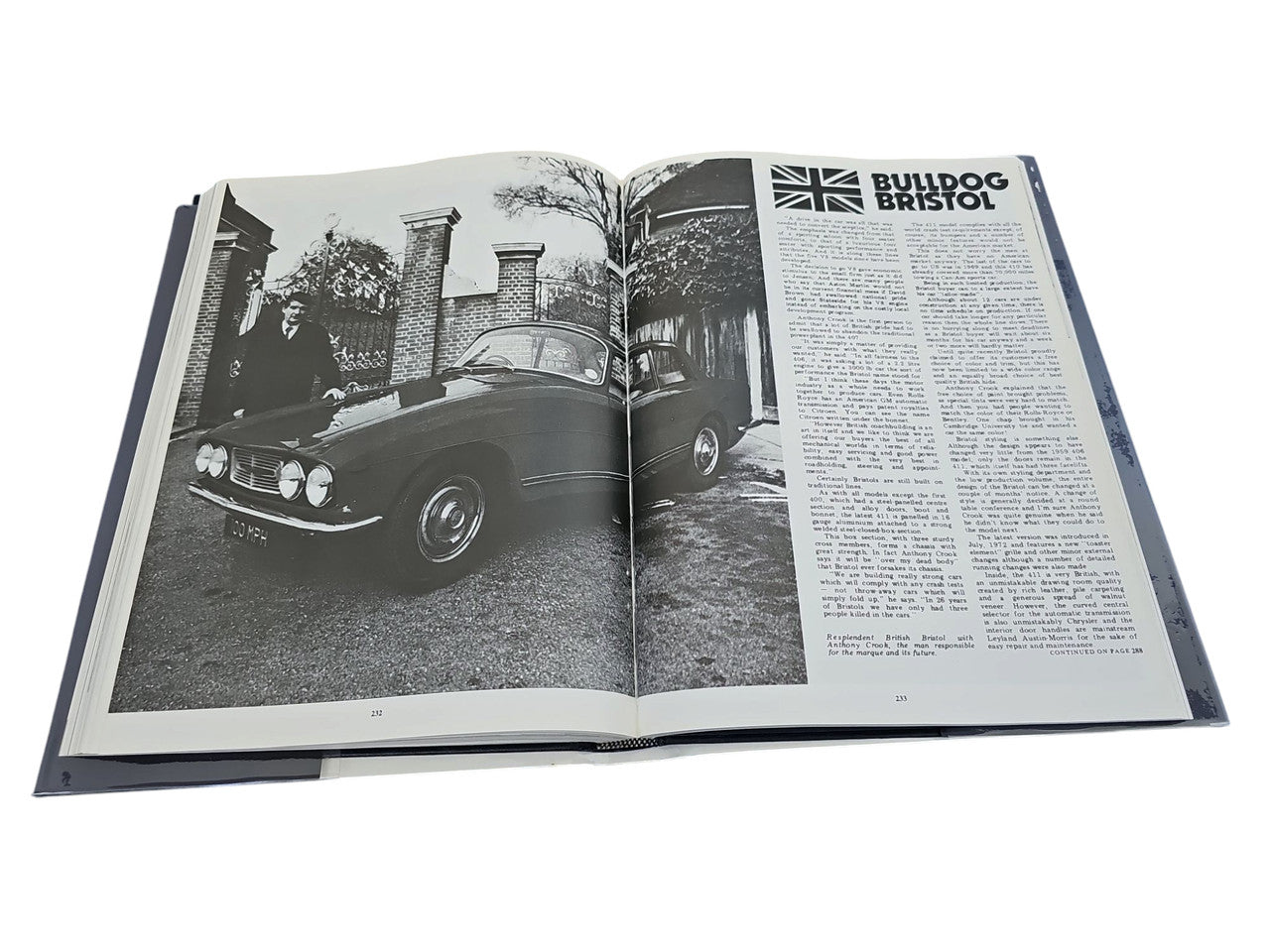 Hardcover automotive portfolio book open to a black-and-white car photo spread
