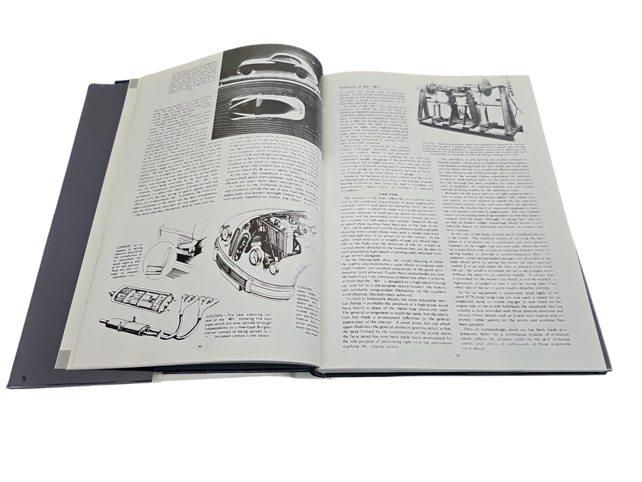 Hardcover automotive portfolio book open to technical text and illustrated diagrams