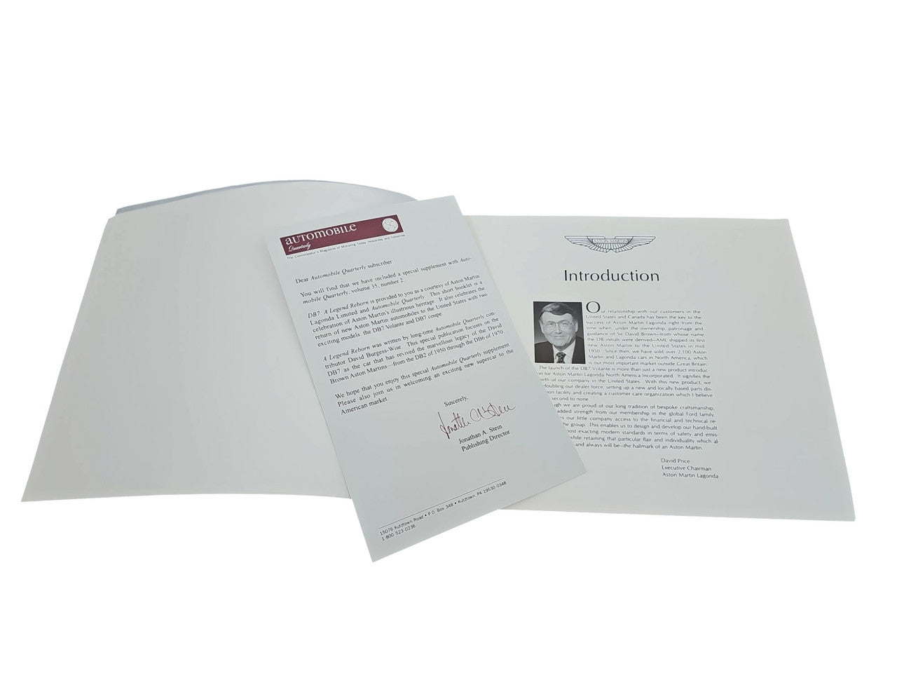 Automobile book with open pages and a loose printed sheet, black text on white