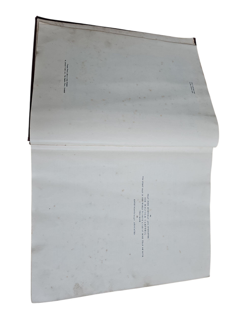 Open vintage manual book with mostly blank pages and small printed text