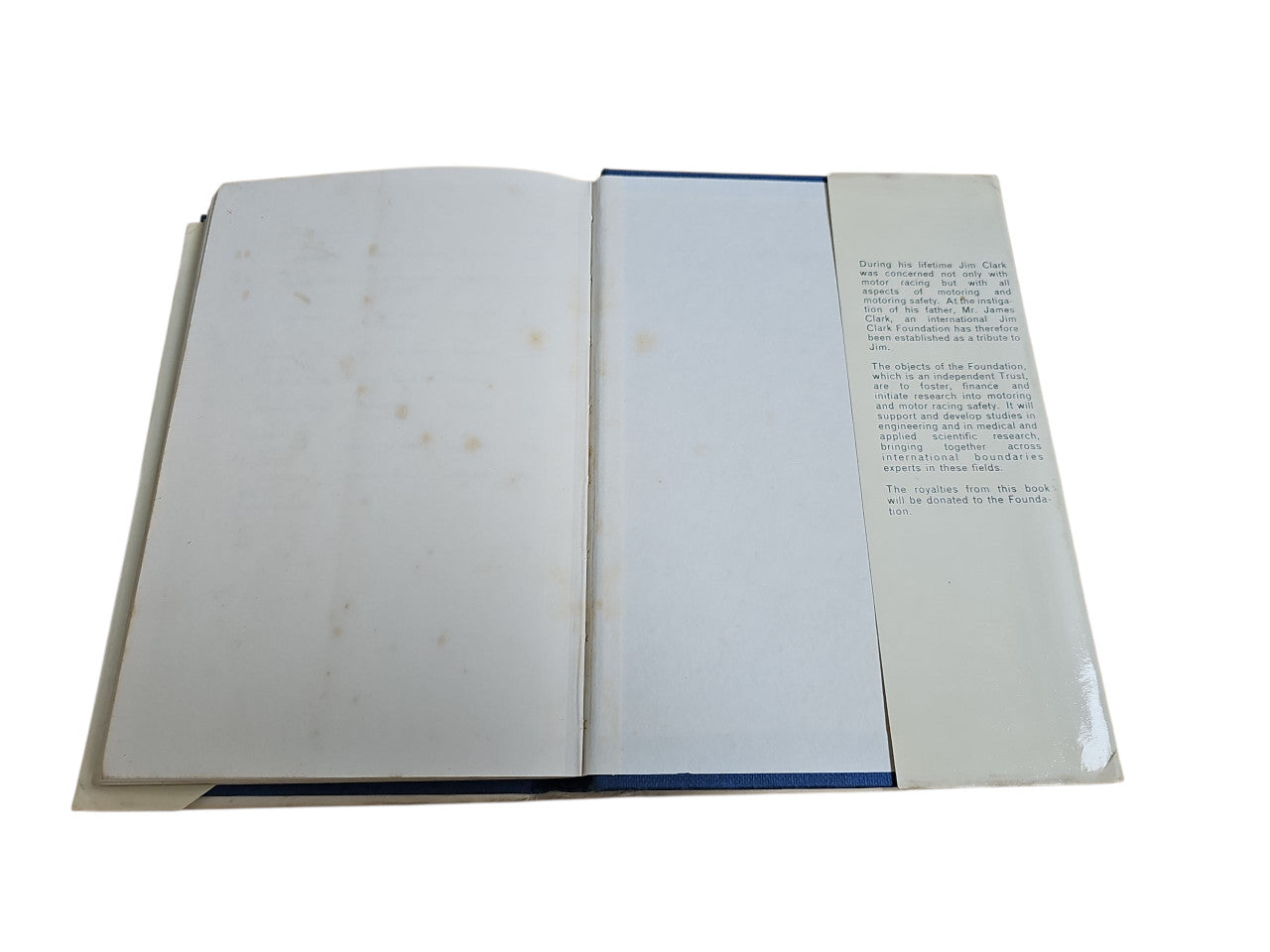 Opened motorsport book showing blank pages with printed text on the right page