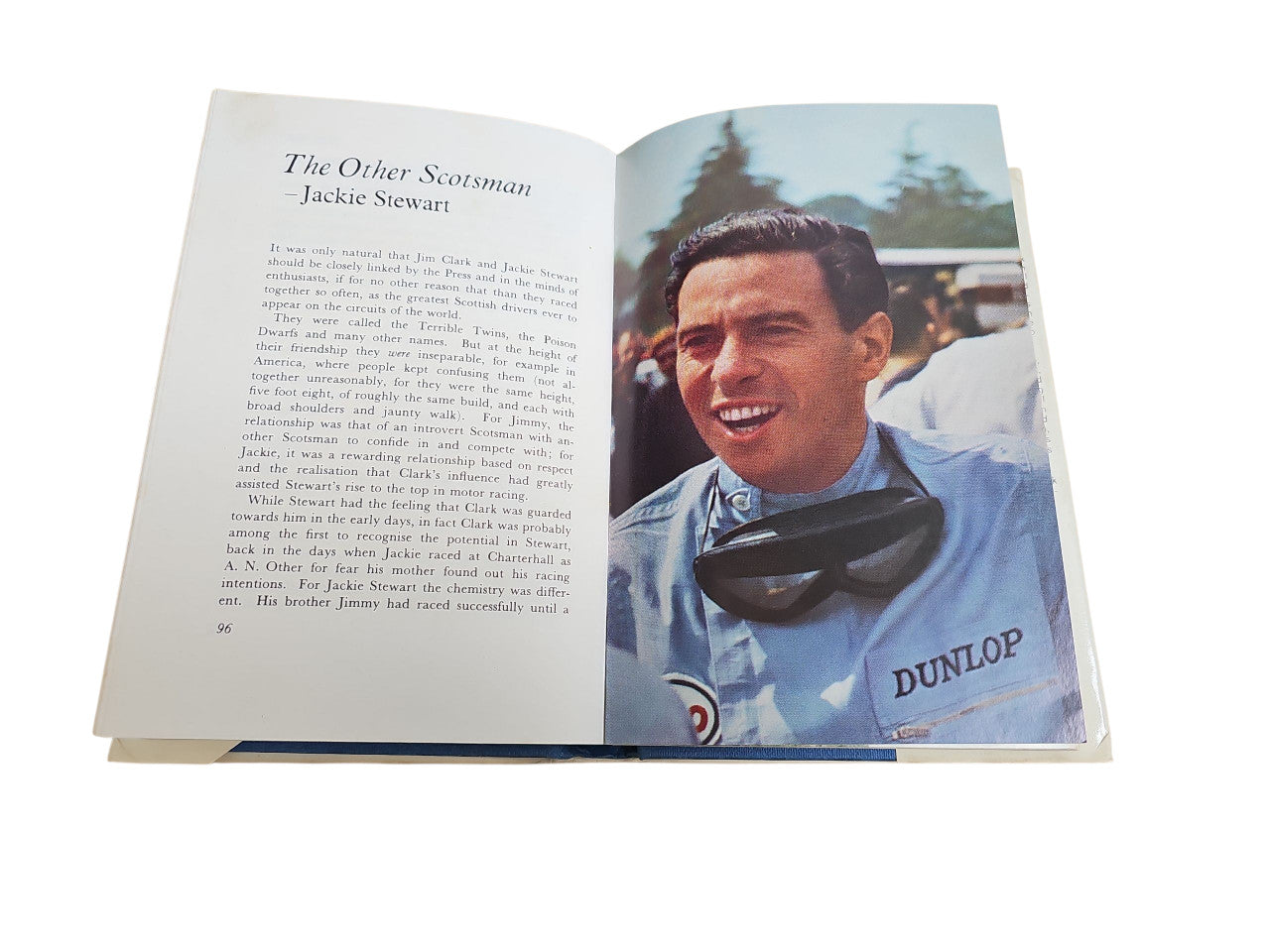 Opened motorsport book with driver portrait photo in blue shirt and text on left